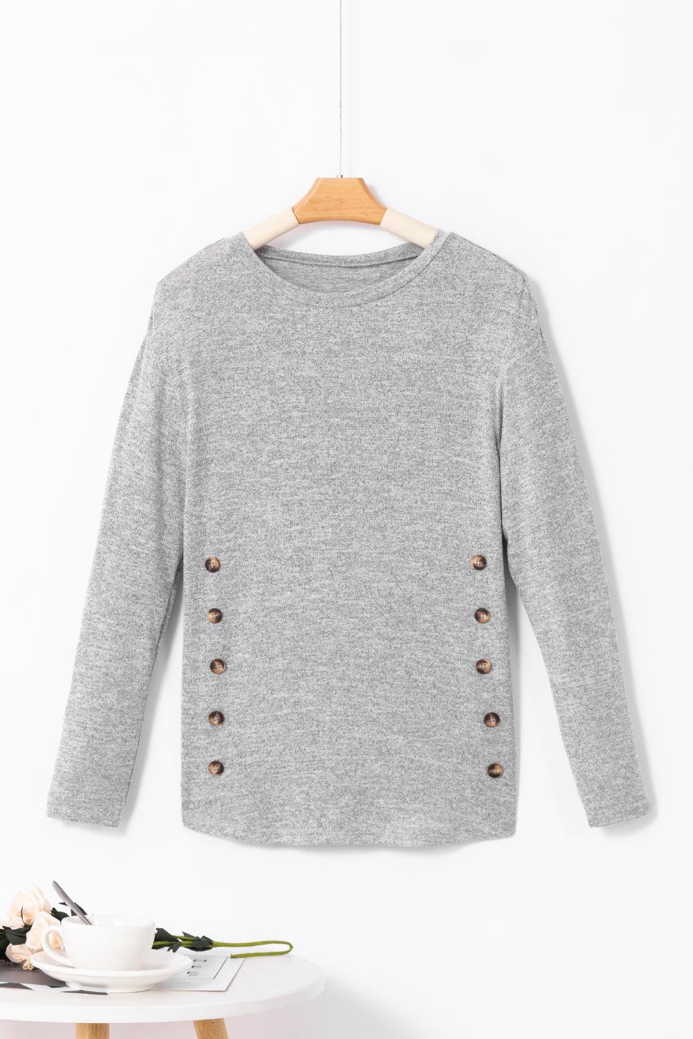 a gray sweater hanging on a white wall