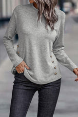 a woman wearing a gray sweater and jeans