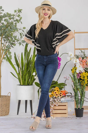 a woman standing in front of a potted plant