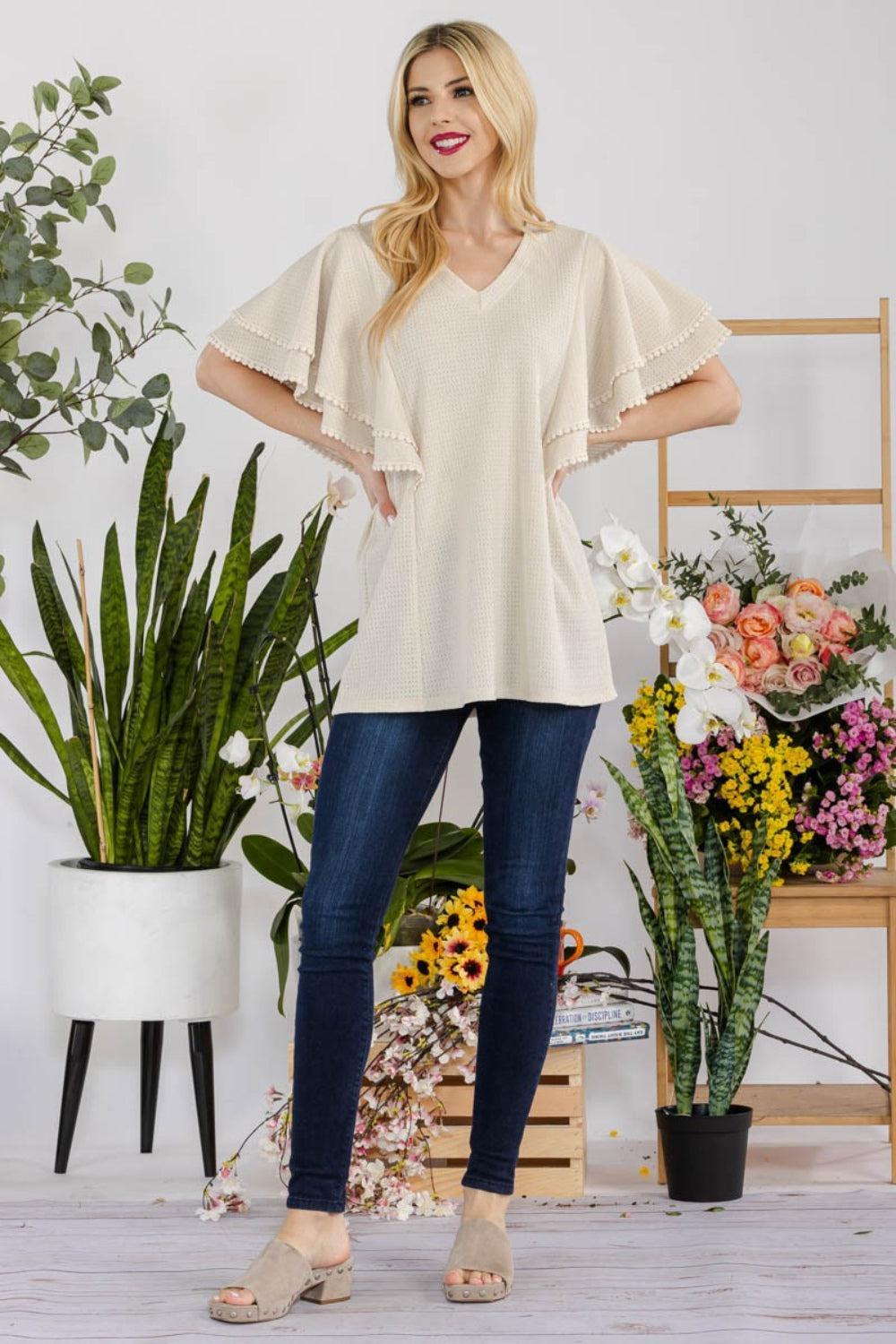 a woman standing in front of a potted plant