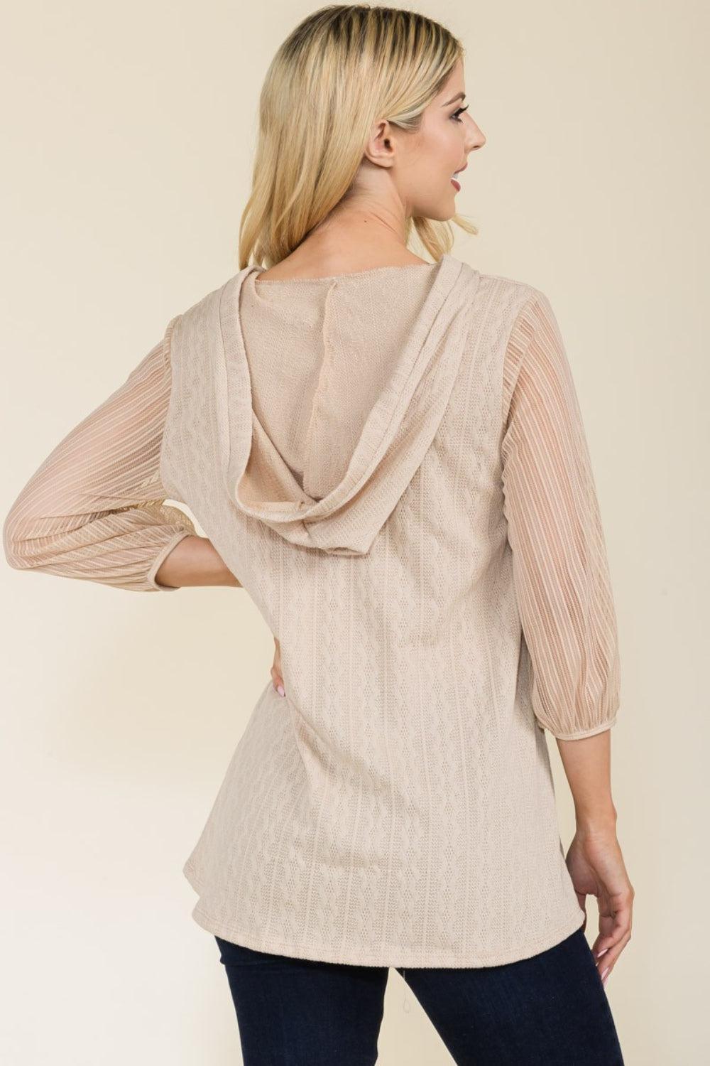 a woman wearing a beige top with a back tie