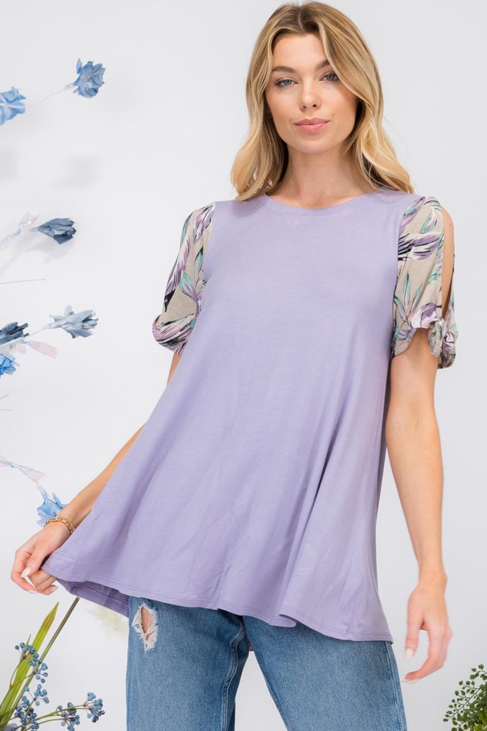 a woman wearing a purple top with floral sleeves