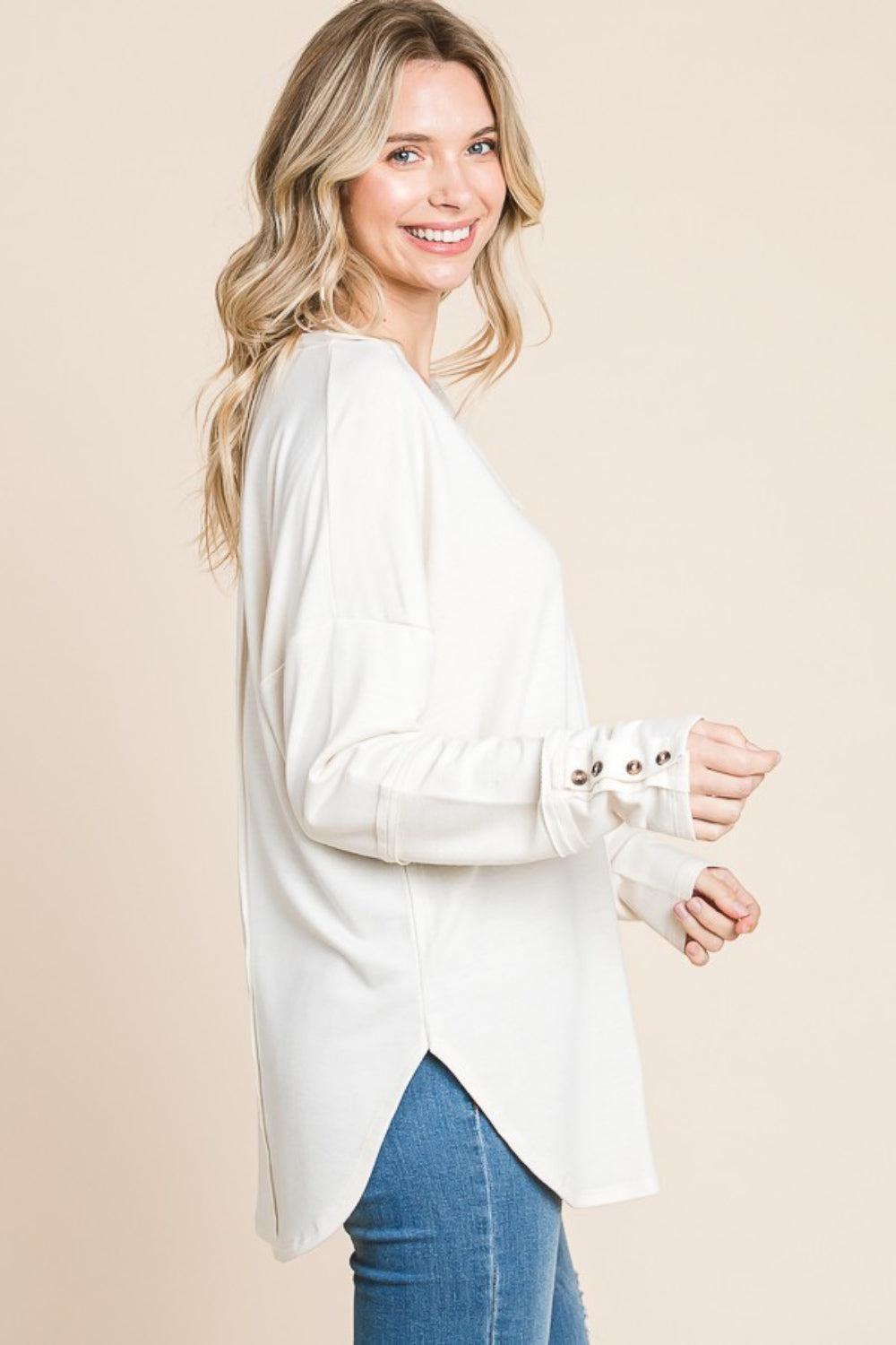 a woman wearing a white top and jeans