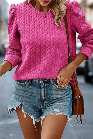 a woman wearing a pink sweater and denim shorts