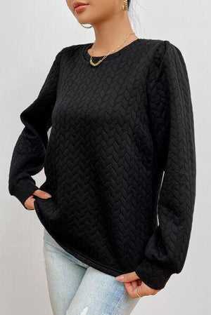 a woman wearing a black sweater and jeans