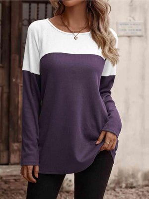 a woman wearing a purple and white top