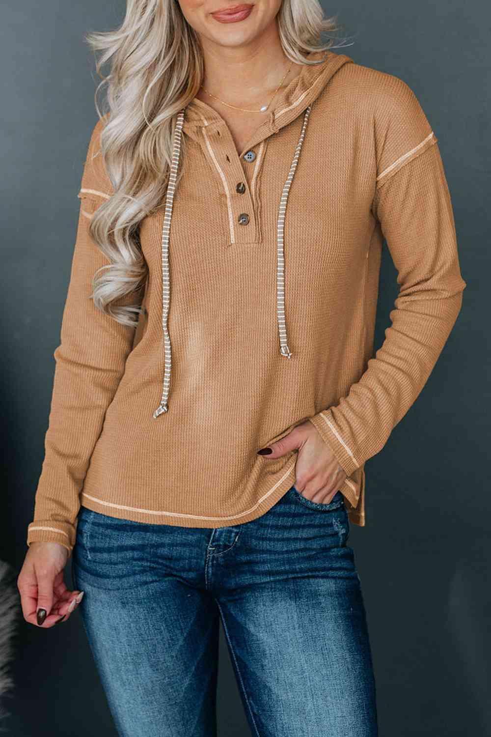 a woman wearing a tan sweater and jeans