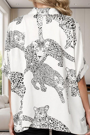 a woman wearing a white shirt with black and white leopards on it