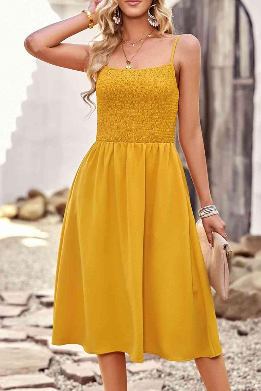 a woman in a yellow dress posing for a picture