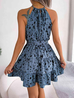 a woman wearing a blue dress with black spots