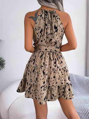 a woman wearing a tan dress with black spots