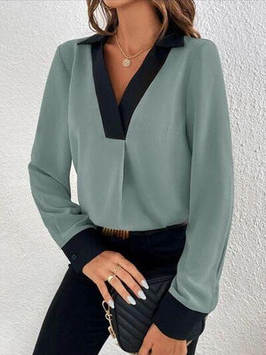 a woman wearing a green blouse and black pants