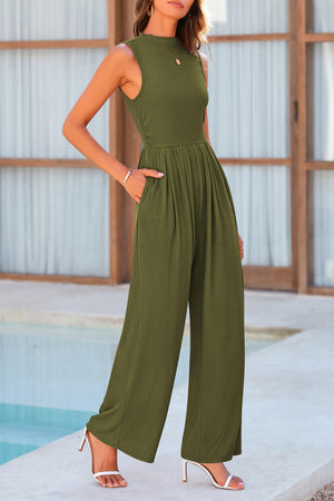 a woman standing next to a pool wearing a green jumpsuit