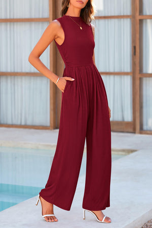 a woman standing next to a pool wearing a red jumpsuit