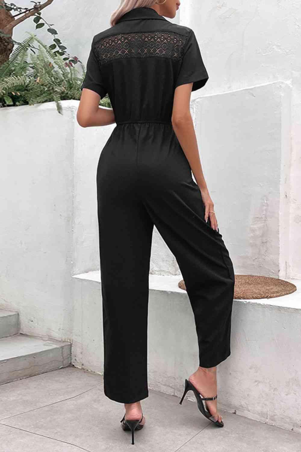 a woman wearing a black jumpsuit and heels