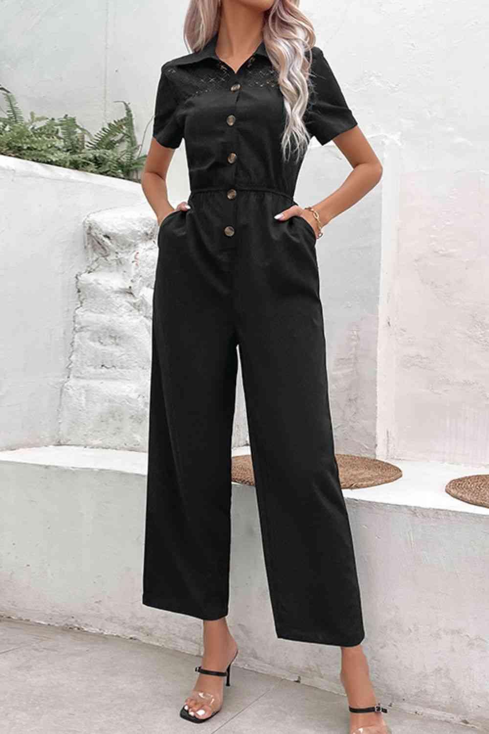 a woman wearing a black jumpsuit and heels