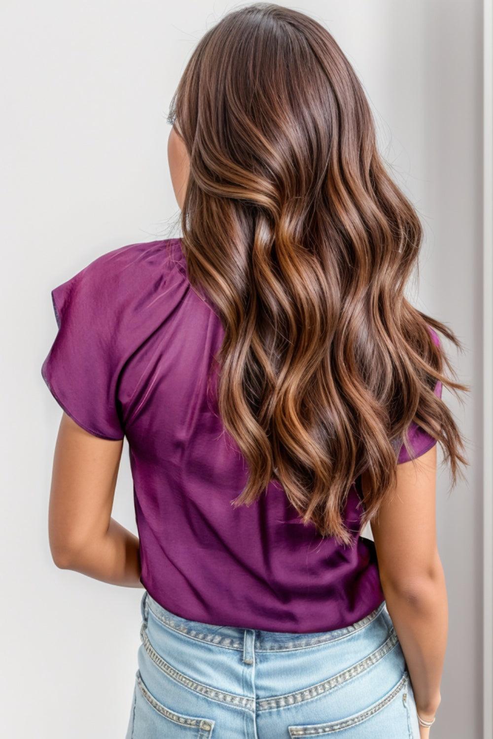 the back of a woman's head wearing a purple top