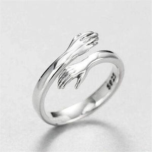 a silver ring with two hands on it