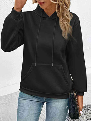 a woman wearing a black hoodie and jeans