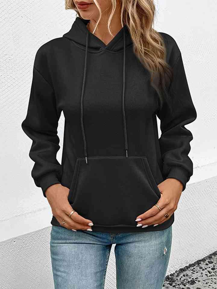 a woman wearing a black hoodie and jeans