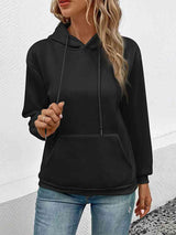 a woman wearing a black hoodie and jeans