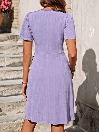 a woman in a purple dress standing on steps