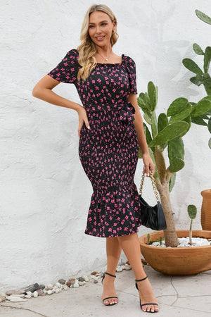 a woman standing in front of a potted plant