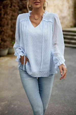 a woman wearing a white blouse and jeans