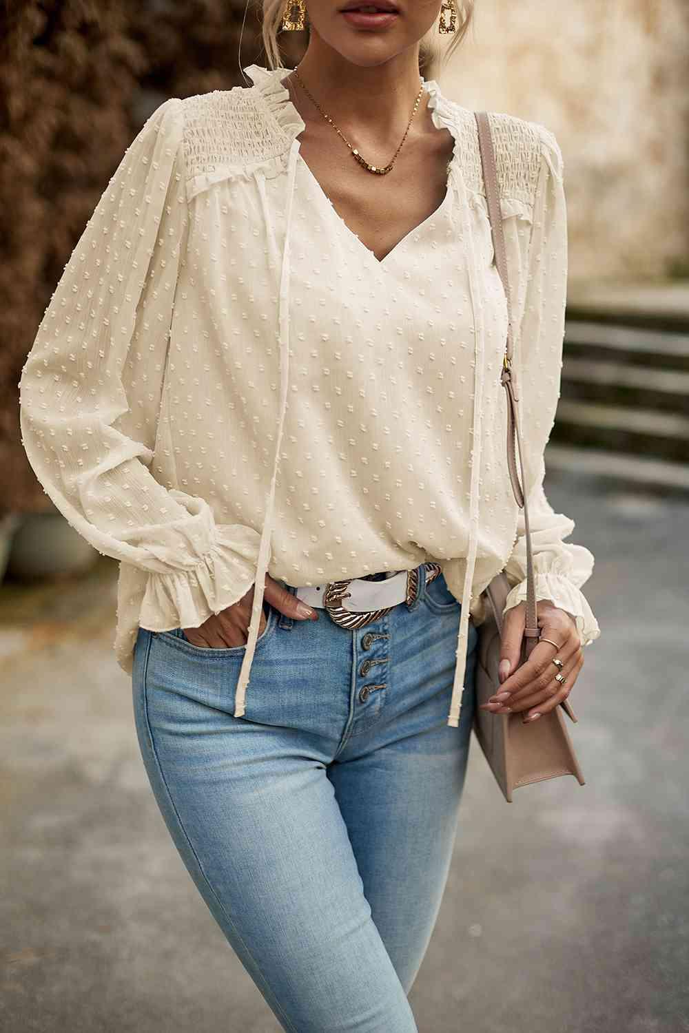 a woman wearing a white blouse and jeans