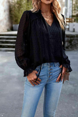 a woman wearing a black blouse and jeans