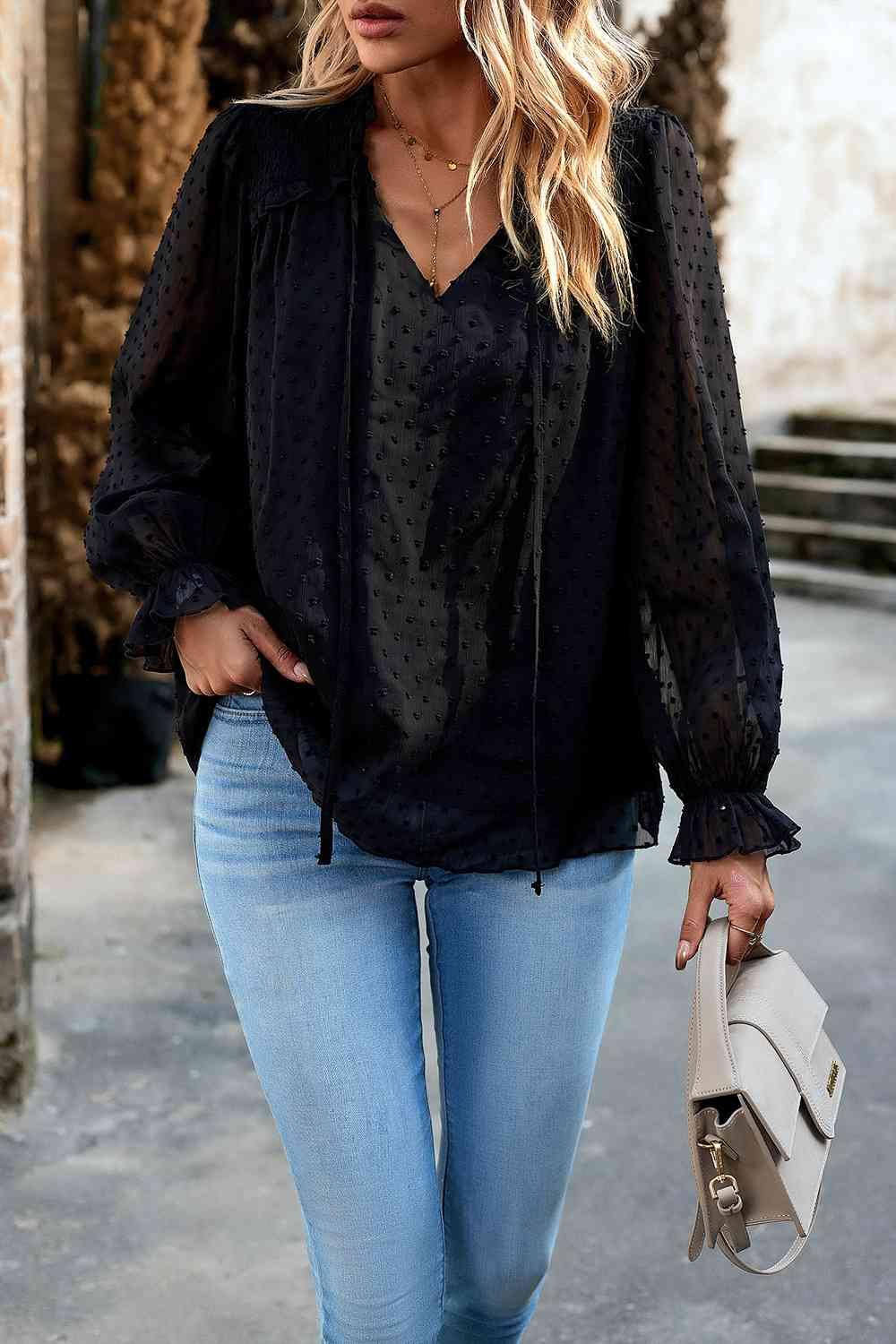 a woman wearing a black blouse and jeans