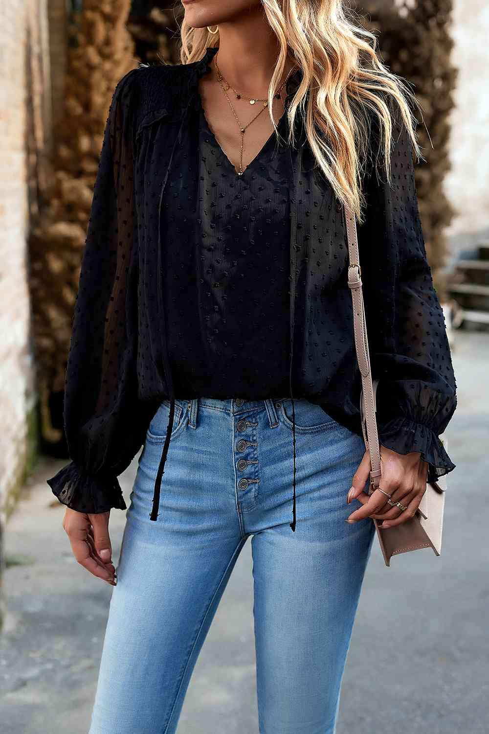 a woman wearing a black blouse and jeans