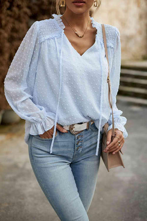 a woman wearing a white blouse and jeans