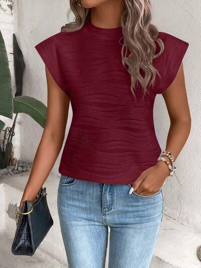 a woman wearing a red top and jeans