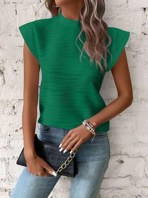 a woman wearing a green top and jeans