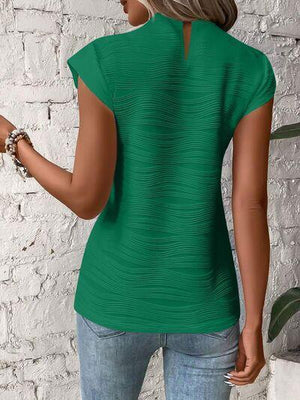 a woman wearing a green top and jeans