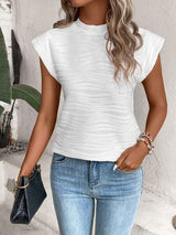 a woman wearing a white top and jeans