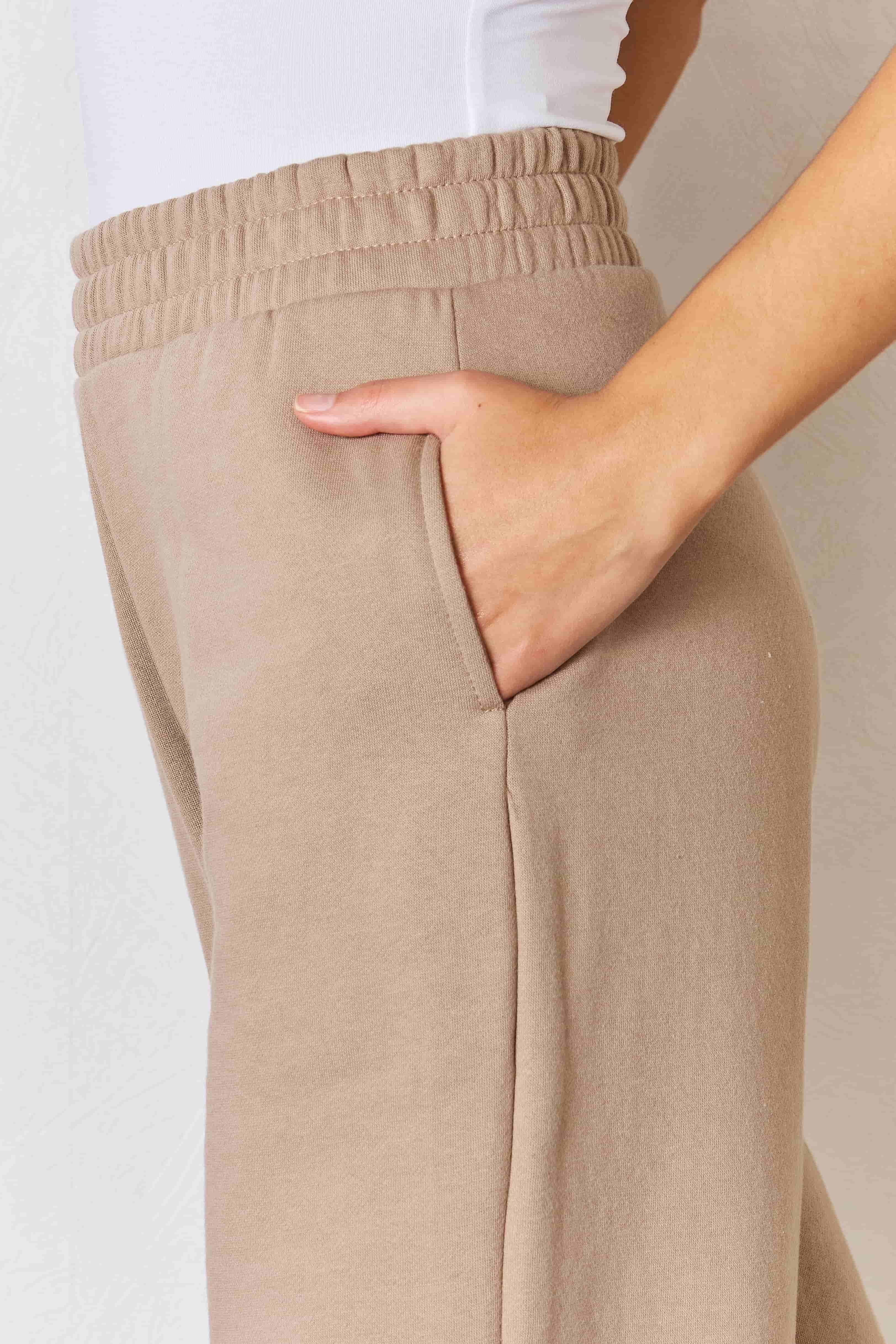 a close up of a woman's pants with her hand on her hip