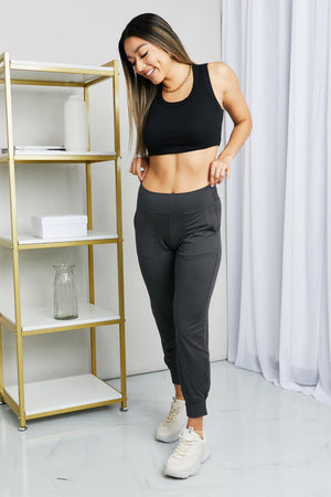 a woman in a black sports bra top and black pants