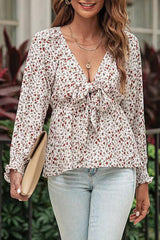 a woman wearing a floral blouse and jeans