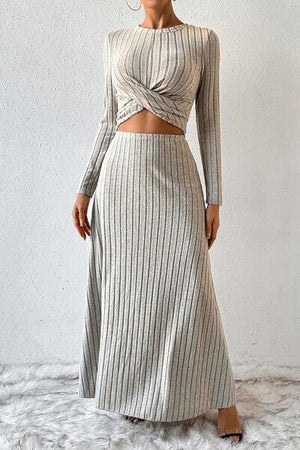a woman wearing a long skirt and a crop top