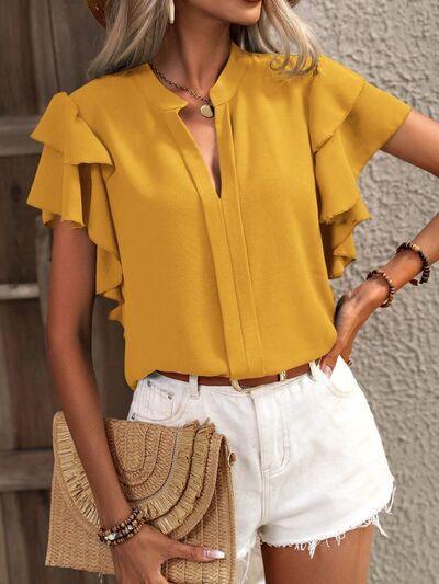 a woman wearing a yellow blouse and white shorts