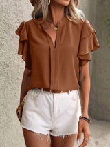 a woman wearing a brown shirt and white shorts