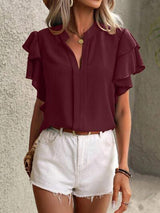 a woman wearing white shorts and a maroon top