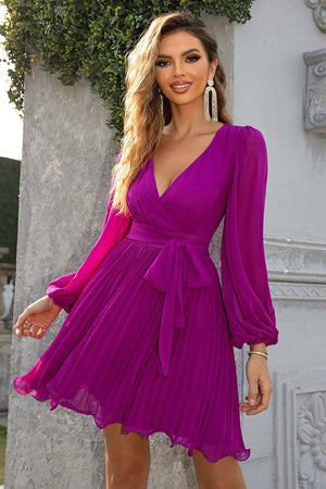 a woman in a purple dress posing for a picture