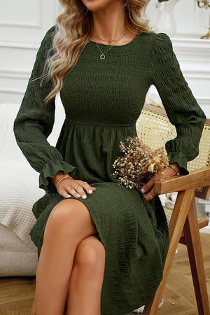 a woman in a green dress sitting on a chair