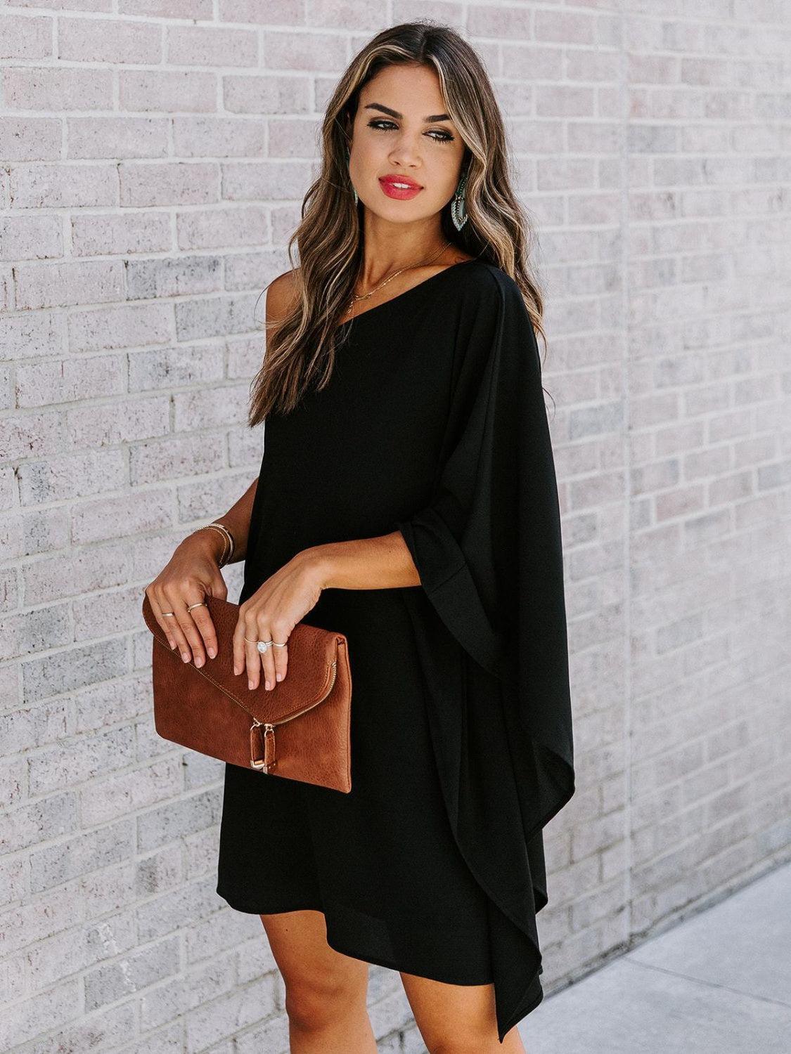 a woman wearing a black dress and a brown purse
