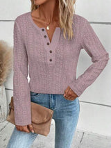 a woman wearing a pink sweater and jeans