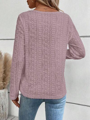 a woman wearing a pink sweater and jeans