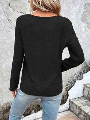 a woman wearing a black sweater and jeans